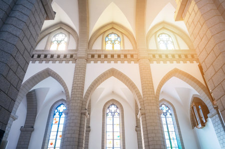 Cathedral of Sacred Heart of Jesus in Tashkent in Uzbekistan. Interior of an Christian Catholic church with sunlight through stained glass windowsの写真素材