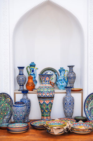 asian Uzbek handmade ceramic vases, plates and dishes hand-painted traditional colorful patterns in pottery workshopの写真素材