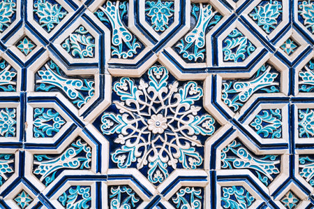 uzbek tile mosaic with traditional oriental Arabic Islamic pattern decorated with blue and white ornament in wall in Uzbekistanの写真素材