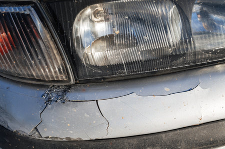 old car after an accident with damaged crumpled bumper close-upの写真素材