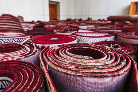 stack of rolled up old Uzbek red carpets at oriental bazaar for sale in Uzbekistanの写真素材