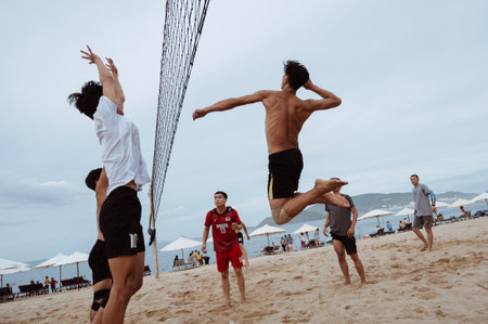 Asian Vietnamese players play beach volleyball on a sandy beach by the sea during summer day in Nha Trang. Nha Trang, Vietnam - July 21, 2024のeditorial素材
