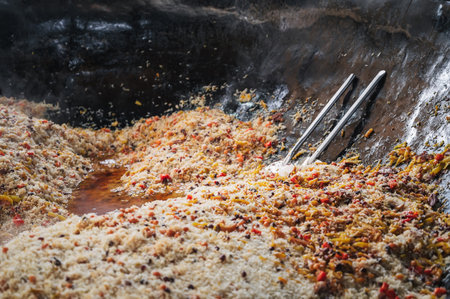 oriental dish of Uzbek cuisine is rice pilaf with vegetables and spices in cauldron in kitchen of Asian restaurant in Tashkent Pilaf Center Besh Qozon in Uzbekistan close-upの写真素材