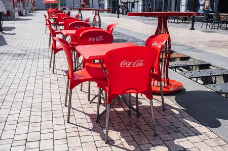 plastic red chairs and tables with Coca-Cola advertising logo in street cafe in summer. Tashkent, Uzbekistan - April 18, 2024のeditorial素材