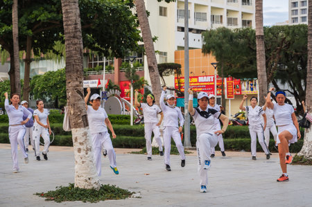 Adult Asian women do sports aerobics in morning on the waterfront in Nha Trang. Nha Trang, Vietnam - July 18, 2024のeditorial素材