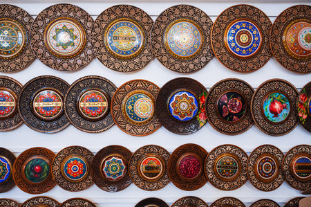traditional Uzbek wooden handmade gift plates with wood carvings hand-painted in souvenir store of Uzbekistan in Tashkentの写真素材
