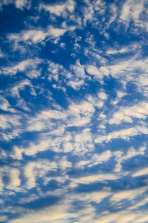 Light cirrus clouds against a light blue sky. Verticalの写真素材