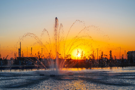 Fountain in the public city park. Sunset in summer.の写真素材