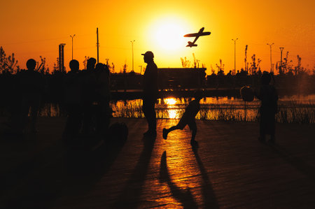 Silhouettes of people having fun in a public park at sunset