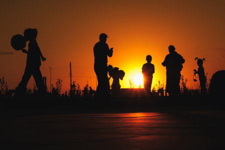 Back view of happy multi generational people having fun in a public park during sunset time - Community and support conceptの写真素材