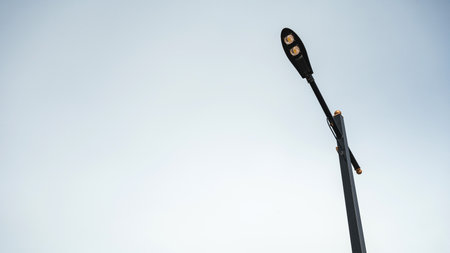 Street light with ushaped fixture illuminates the winter evening skyの写真素材