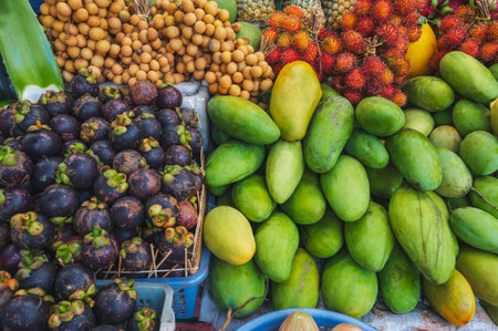 An assortment of various tropical exotic Asian fruits on counter at the market in Thailandの写真素材