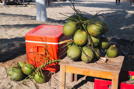 A bunch of green drinking coconuts on the background of a sandy beach