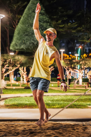 male acrobat walks on rope and trains slackline on the beach. Nha Trang, Vietnam - July 25, 2024のeditorial素材