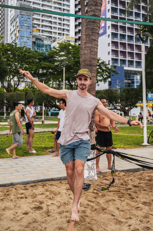 A male acrobat in slackline training walks a tightrope on beach in summer. Nha Trang, Vietnam - July 25, 2024のeditorial素材