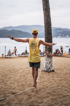 male acrobat walks on rope and trains slackline on the beach. Nha Trang, Vietnam - July 25, 2024のeditorial素材