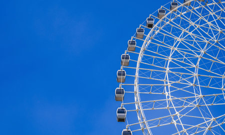 white big Ferris wheel on background a blue sky in amusement park at fair in summer with copy space