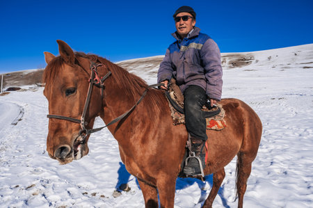 A Kazakh man on horse in winter in a snowy steppe. Shymkent, Kazakhstan - January 27, 2024のeditorial素材