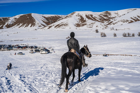 The back of a Kazakh teenager on a horse in steppes of Kazakhstan in winter. Shymkent, Kazakhstan - January 27, 2024のeditorial素材