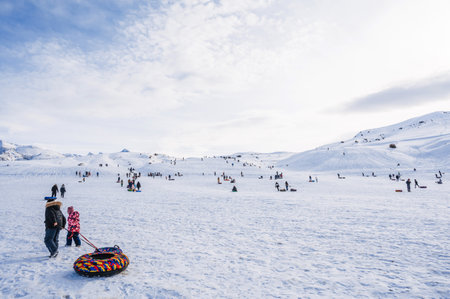 People relax and roll down slide on tubing in winter in nature in the mountains of Kazakhstan. Shymkent, Kazakhstan - January 27, 2024のeditorial素材