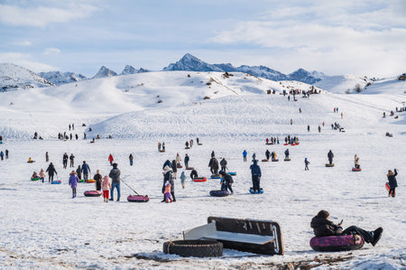 People ride downhill on tubing in winter outdoors on recreation in mountains in nature. Shymkent, Kazakhstan - January 27, 2024のeditorial素材