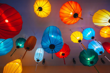 Traditional multicolored silk hanging Chinese lanterns from ceiling of an Asian cafe for interior decorationの写真素材