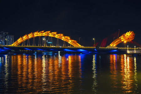 Dragon Bridge over Han River in city of Da Nang in Vietnam at night with a golden backlightの写真素材