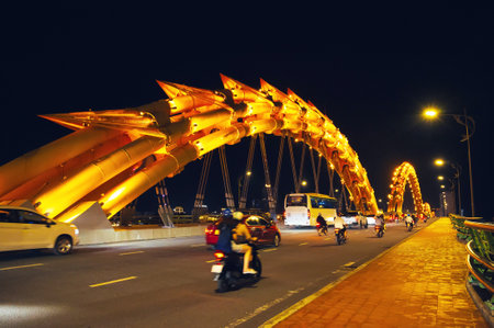 Motorcycle traffic on the Dragon Bridge over Han River in Da Nang, Vietnam at nightの写真素材