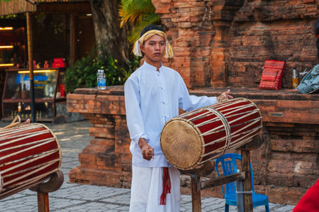 Portrait of a Vietnamese teenager boy musician playing a traditional drum at Po Nagar Cham Towers Festival in Nha Trang in Asia. Nha Trang, Vietnam - August 8, 2024のeditorial素材