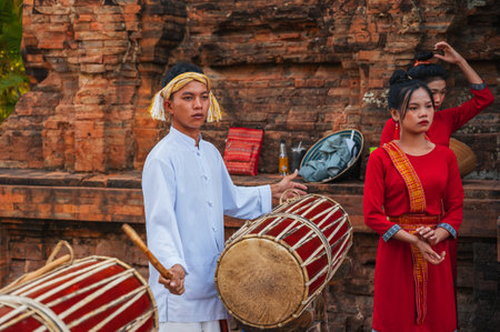 Vietnamese teenager boy musician playing a traditional drum at the Po Nagar Cham Towers in Nha Trang. Nha Trang, Vietnam - August 8, 2024のeditorial素材
