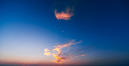 blue sky with gentle clouds at sunset in summerの写真素材