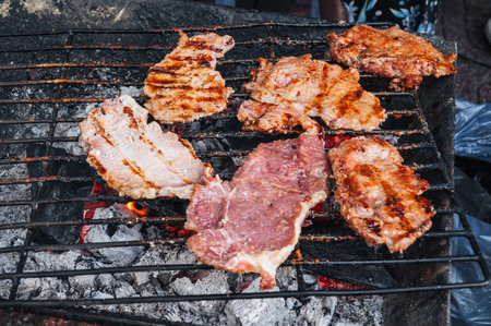 cooking steak on a hot grill outside.