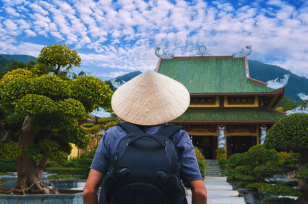 back of a male tourist traveler at a Buddhist temple at Linh Ung Pagoda in Da Nang in Vietnam. The...