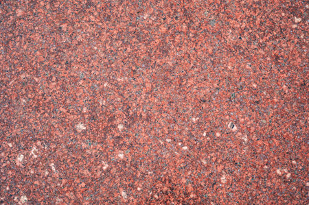 background with red granite tile texture. The texture of natural granite stone for decoration of facades and sidewalksの写真素材