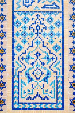 ancient old wall of a Muslim mosque decorated with ceramic tiles with a traditional oriental Uzbek...