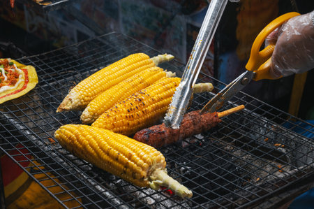 grilled corn and meat sausage grilled on fire at Asian street night market in Vietnam in Asiaの写真素材