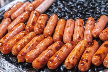 Grilled sausages on rocks at Asian night market. Street fast food in Asiaの写真素材