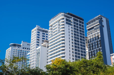 facades of tall modern hotels and skyscrapers against the blue sky in summer in resort town in Asia