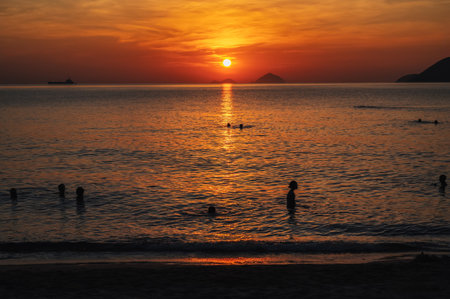 Silhouettes of people swimming in sea at sunrise in the morning on vacation in summer in Asia