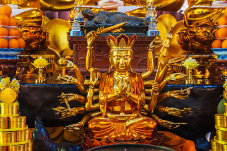 golden Shiva figurine on an altar inside a Buddhist templeの写真素材