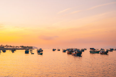 Traditional Vietnamese fishing boats at sea in Vietnam at sunset in Asiaの写真素材