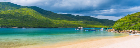 white sandy beach on a tropical island in a bay by the sea on a summer. Landscape panorama with a view of the coast by oceanの写真素材