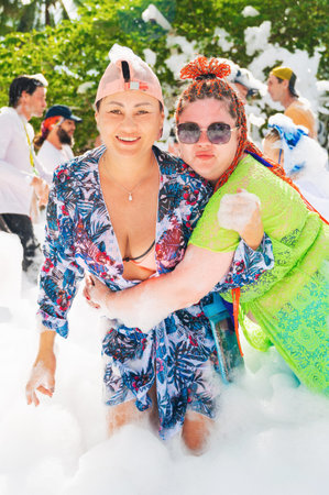 Happy female friends smile at a foam party on summer vacation at a resort. Nha Trang, Vietnam - November 1, 2025のeditorial素材
