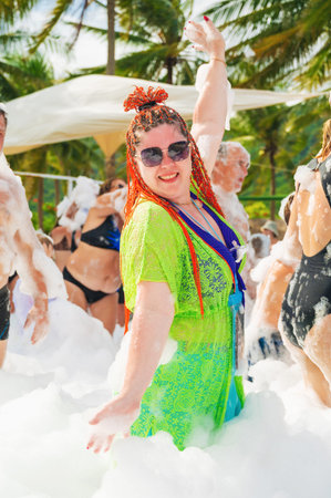 A happy joyful adult woman is dancing at a foam party on a summer vacation at resort. Nha Trang, Vietnam - November 1, 2025のeditorial素材