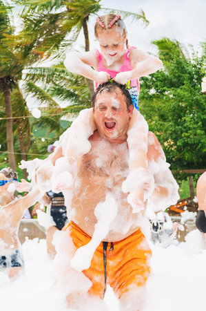 Happy dad and daughter are smiling and dancing at foam party on a summer vacation. Nha Trang, Vietnam - November 1, 2025のeditorial素材