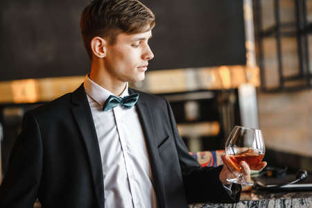 A business man holds a glass of wine.の写真素材