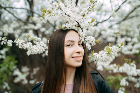 Young woman with cherry flowers portraitの写真素材
