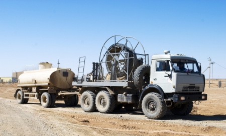 The truck pulls the tank with fuel on industrial siteの写真素材