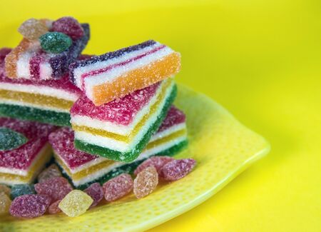 colored pieces of marmalade on a yellow backgroundの写真素材