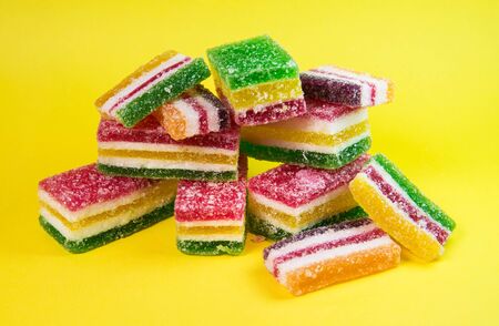 colored pieces of marmalade on a yellow backgroundの写真素材